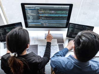 Zwei Menschen analysieren gemeinsam am Computer