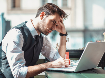 Mann arbeitet angestrengt an Laptop