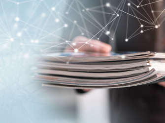 Hand hält Broschüren und ein Layer mit Netzlinien ist darübergelegt.