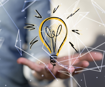 Eine leuchtende Glühbirne auf einer Hand