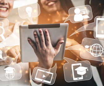 Lachende Personen schauen auf ein Tablet. Rund um das Tablet sind Symbole angeordnet.