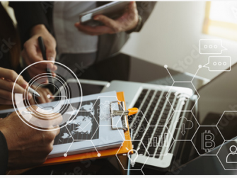 Leute schauen auf ein Klemmbrett und auf einen Laptop