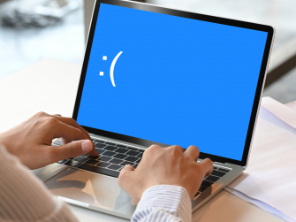 Foto eines Laptops mit Bluescreen auf dem :( abgebildet ist