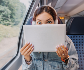Frau versteckt sich Hinter Laptop in der Bahn